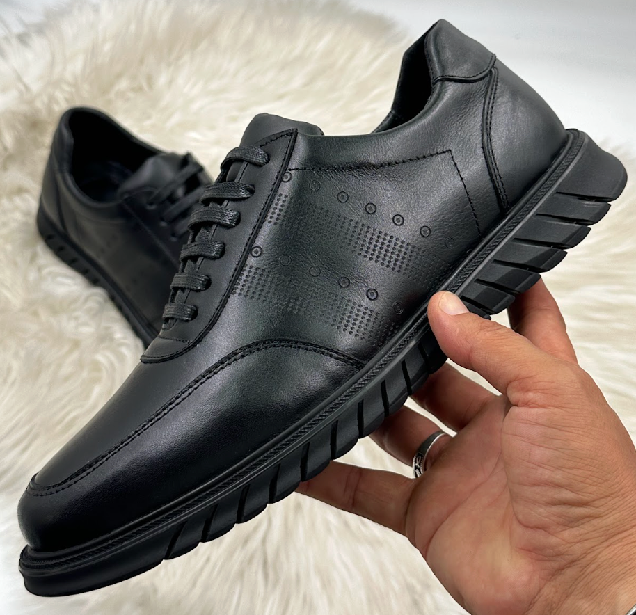 Sneakers cuir semelle crantée - vue latérale tenue en main